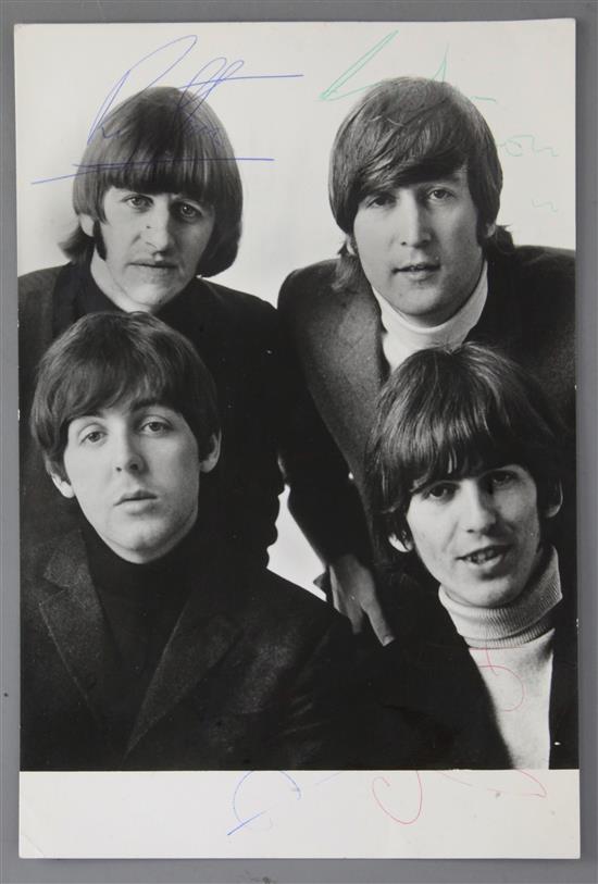 The Beatles. A photograph of the band signed in blue, green and red ink by the individual members,